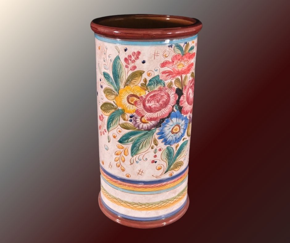 An elegant ceramic umbrella stand in pink hues and colorful flowers and cylindric shape to elevate any entry.
